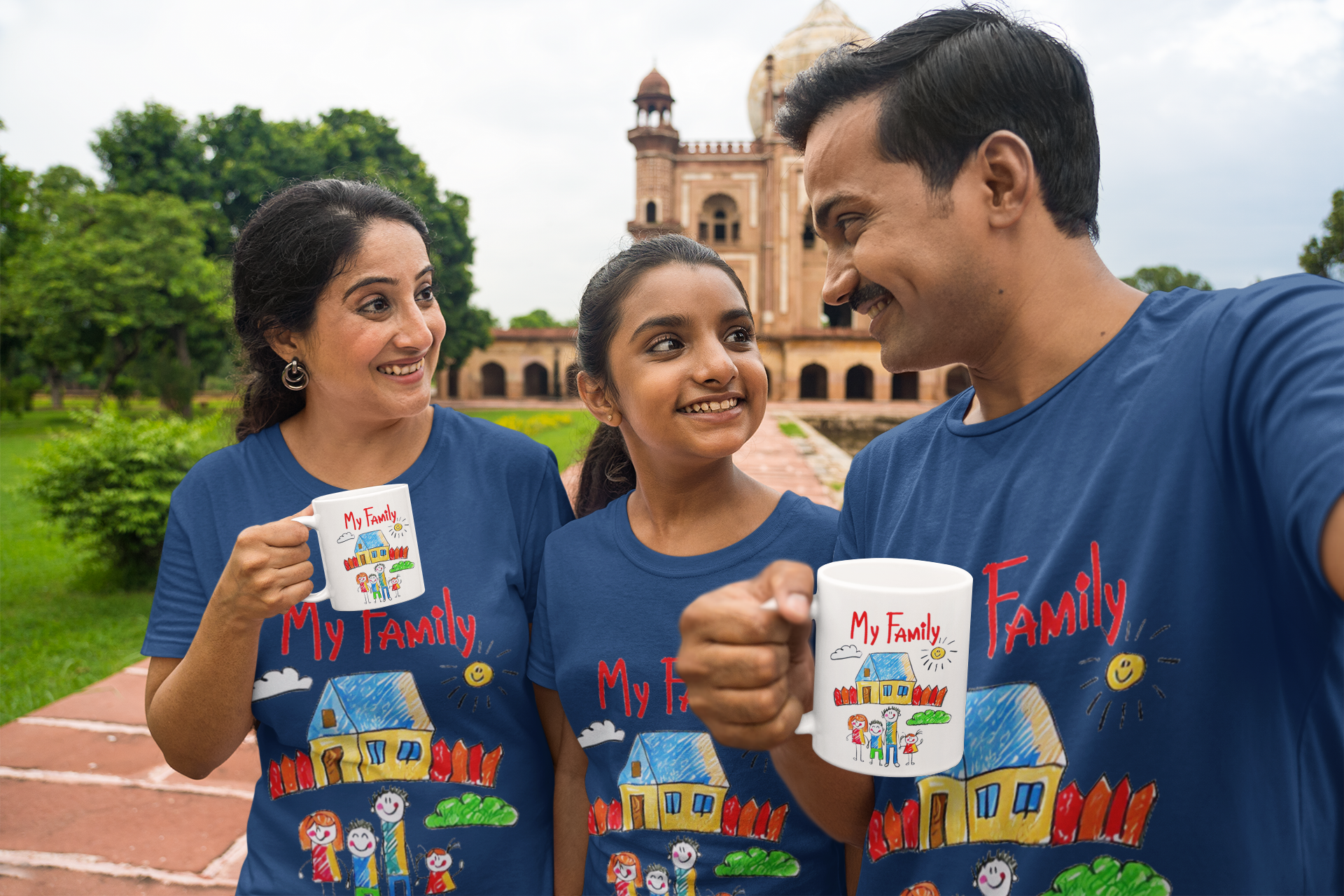 Family wearing matching "My Family" t-shirts and holding mugs with a colorful house design.