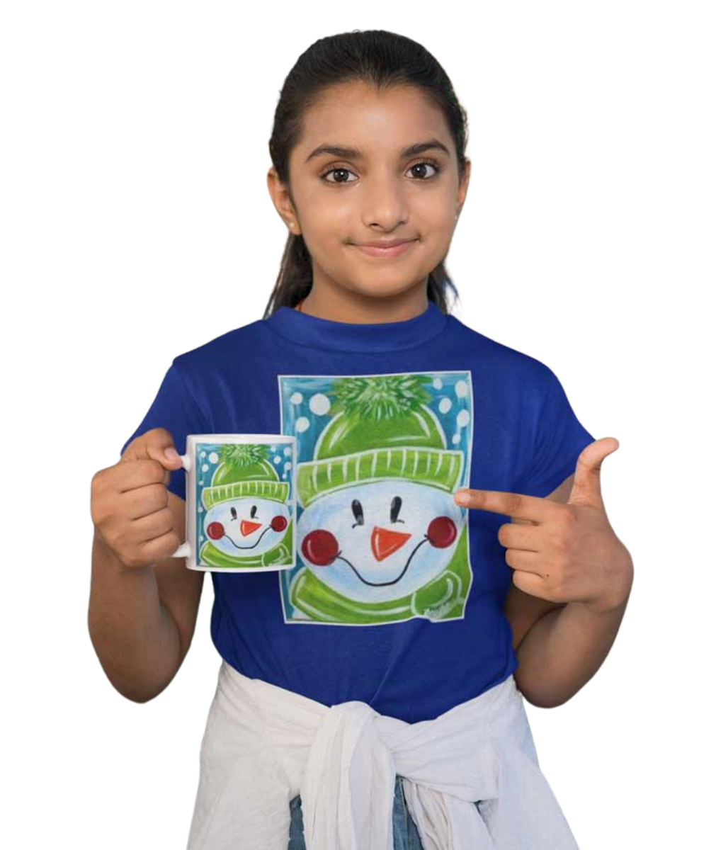 A girl wearing a blue t-shirt with a snowman design, holding a matching mug and pointing at it.